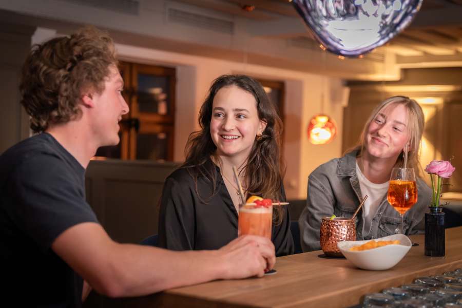 Gäste genießen Drinks an der Bar Xaver in Schliersee