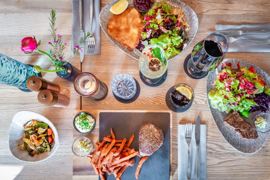 Schnitzel Wiener Art mit Beilagensalat und Rindersteak mit Süßkartoffelpommes im Restaurant Xaver in Schliersee