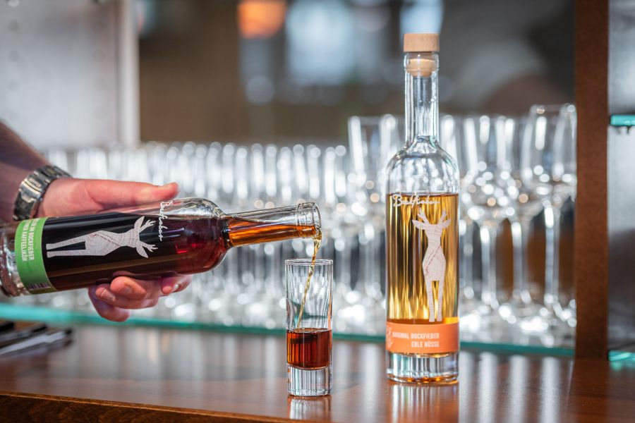 Barkeeper schenkt Likör in ein Glas in der Bar Xaver in Schliersee