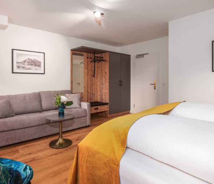 Superior room at Hotel Terofal in Schliersee with double bed and sofa