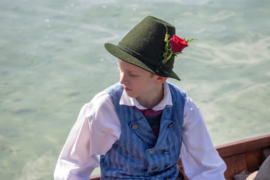 Junger Trachtenträger mit Hut auf einer historischen Plätte am Schliersee