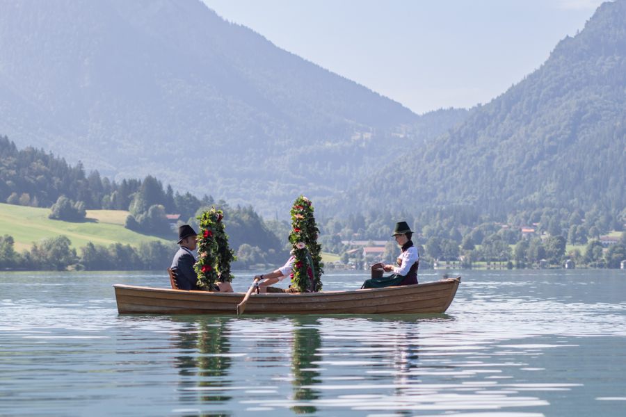 Drei Trachtenträger auf einer kleinen Plätte auf dem Schliersee