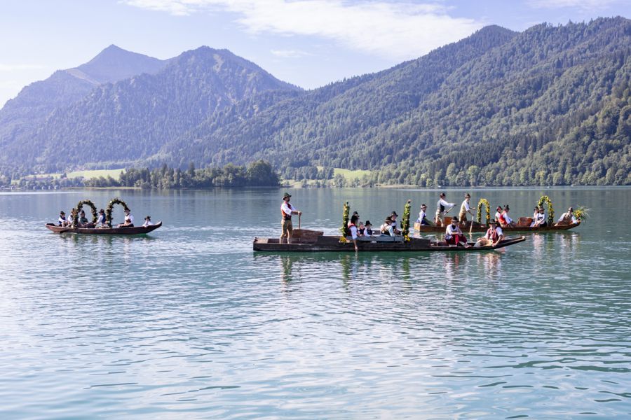Historische Plätten mit Trachtengruppen vor den Bergen am Schliersee