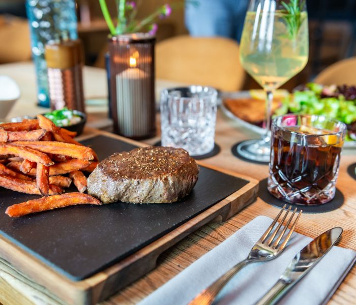 Beef steak with sweet potato fries, served with homemade herb butter and a refreshing cola