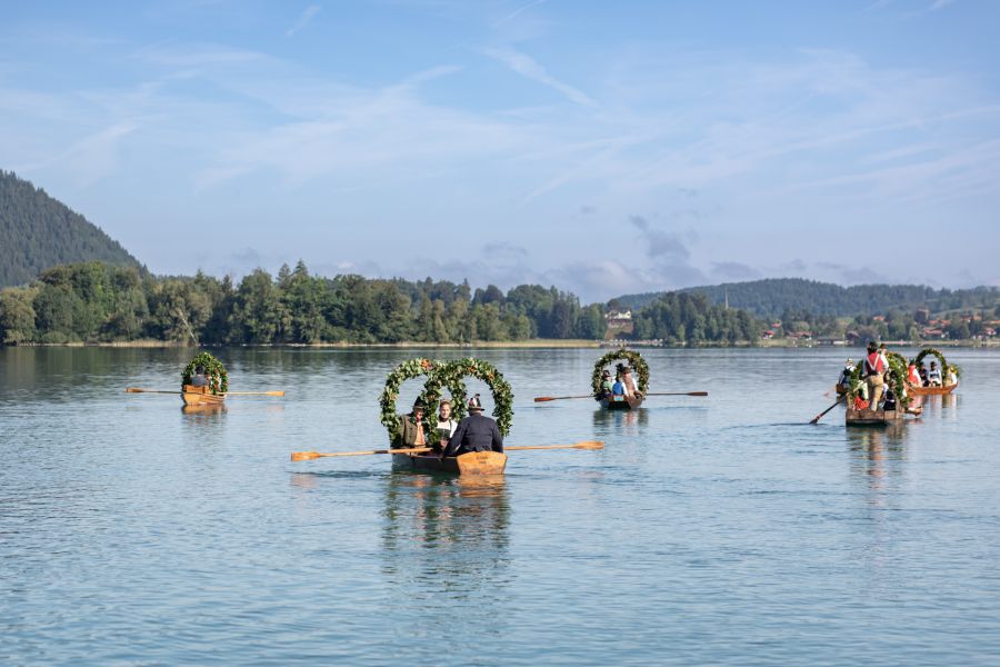 Mehrere historische Plätten mit Trachtengruppen auf dem Schliersee