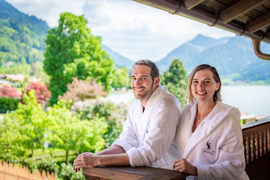 Two guests enjoying the view of the lake and surrounding mountains from the balcony of the “Leni” holiday apartment at Seeheimat in Schliersee