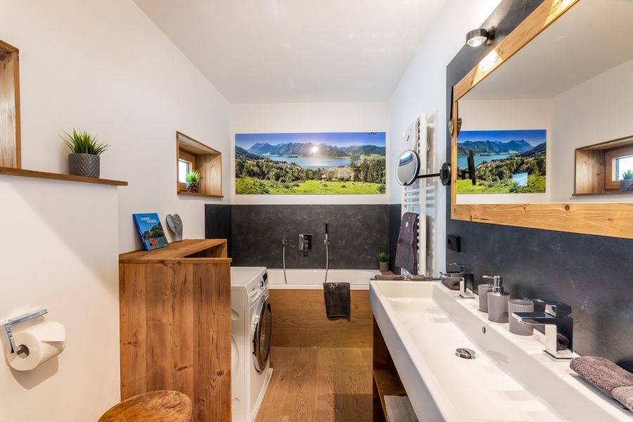 Badezimmer mit Badewanne und Waschmaschine der Ferienwohnung Franzl in der Seeheimat in Schliersee