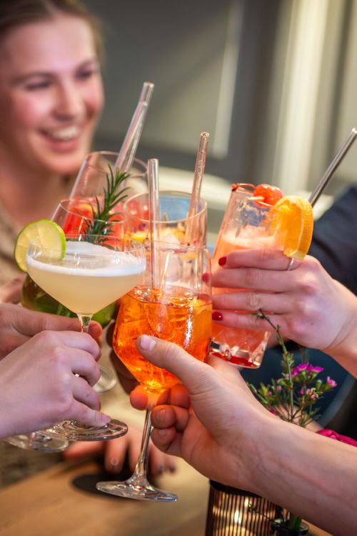 Guests clinking glasses with cocktails and drinks at Bar Xaver in Schliersee