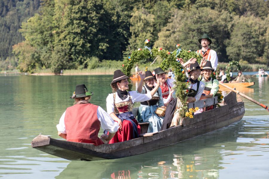 Trachtengruppe auf einer festlich geschmückten Plätte am Schliersee