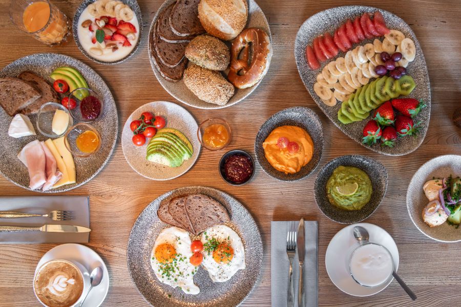Selection from the breakfast buffet with egg dish, freshly sliced fruit, bread basket, and fresh spreads at Hotel Terofal in Schliersee