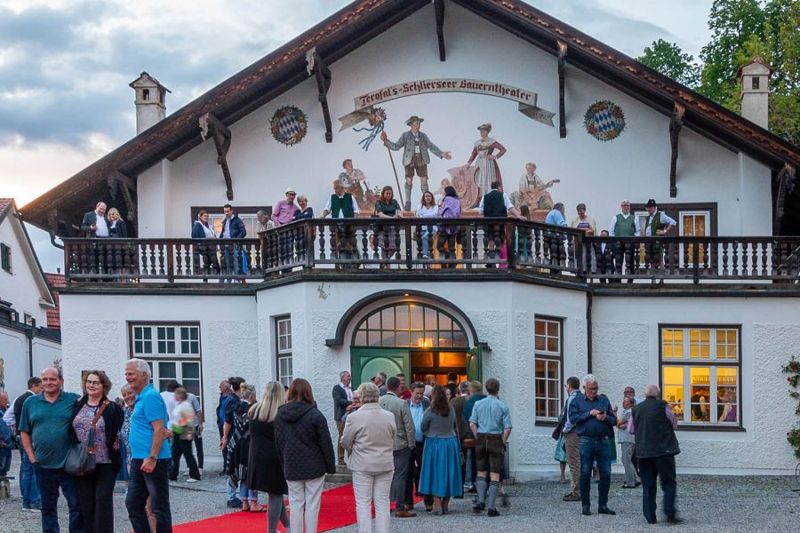 Visitors to the Bauerntheater in Schliersee waiting in front of the historic building for admission to the theater performance