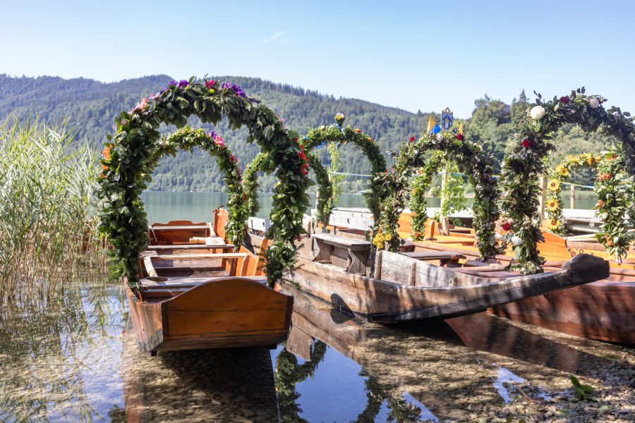Blumengeschmückte historische Plätten am Ufer von Schliersee