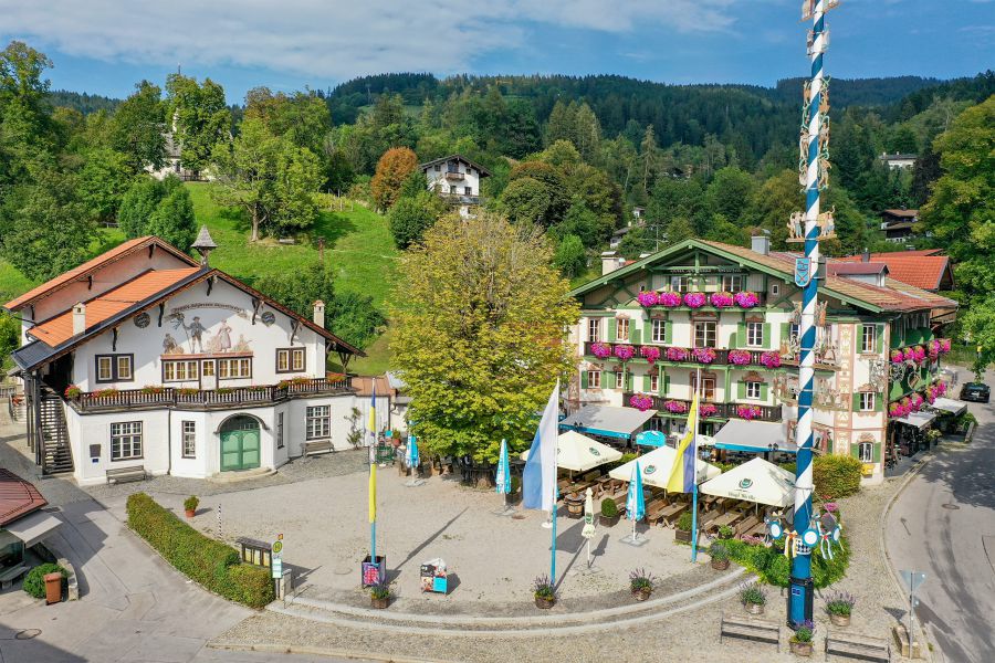Luftaufnahme vom Hotel Terofal mit Biergarten und Maibaum, links daneben das historische Bauerntheater