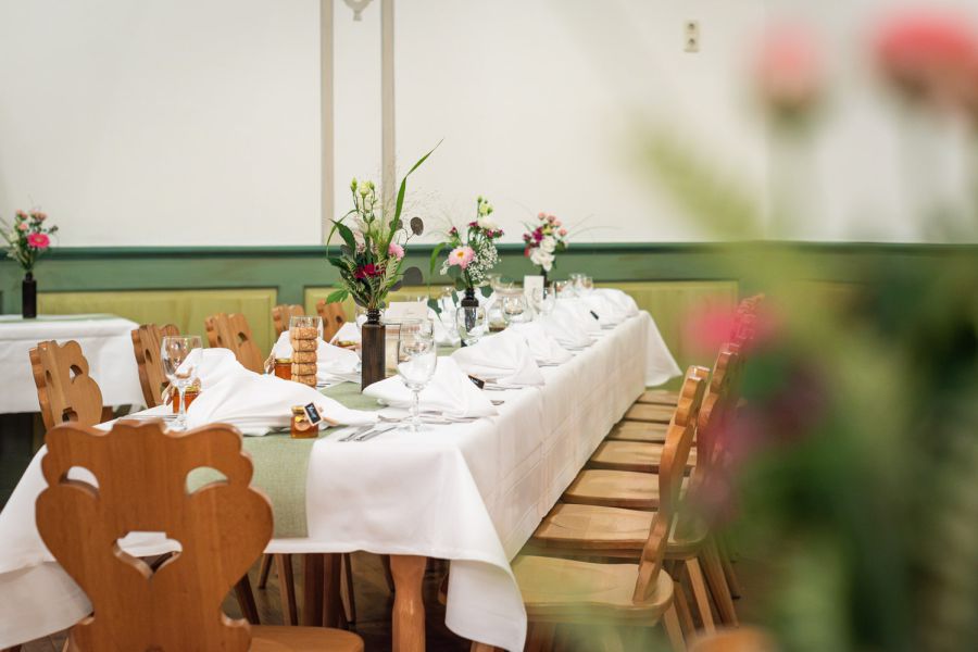 festlich eingedeckter Tisch mit Blumenschmuck im Bauerntheater in Schiersee