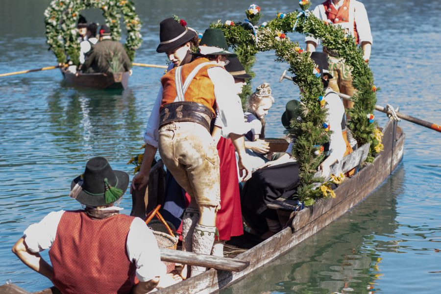 Trachtengruppe auf einer blumengeschmückten Plätte bei der Bootsüberfahrt